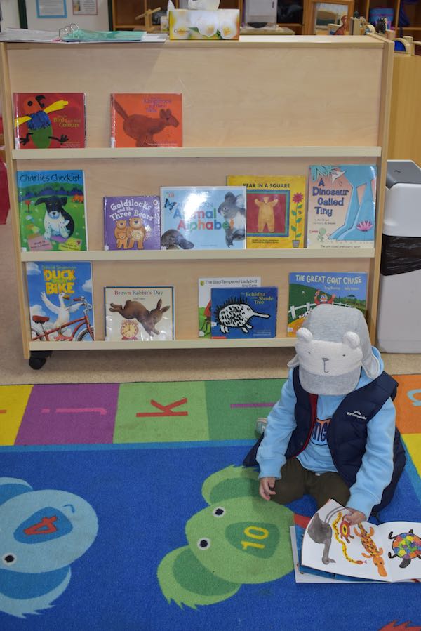 Child reading in front of a bookcase