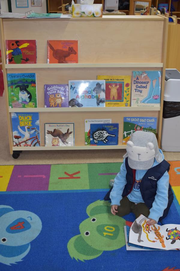 Child reading in Kindy C Room